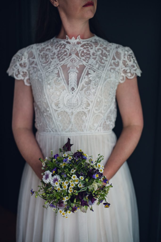 wild-blossoms-bouquet-styles-dresses-web-199 bride holding a small purple garden style bouquet