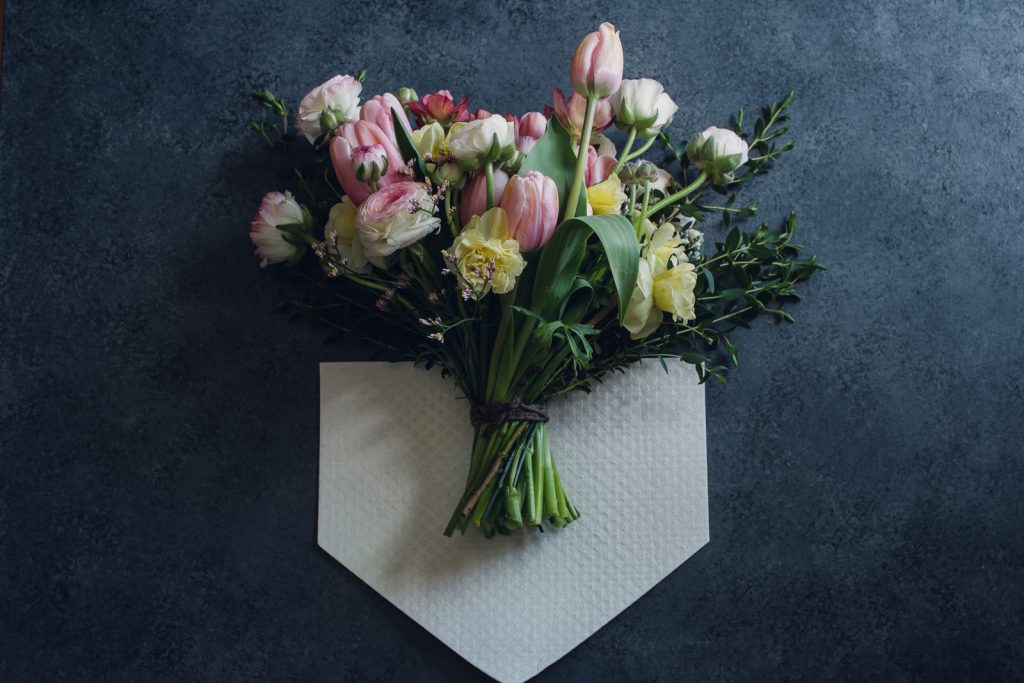 wild-blossoms-gift collection-pressed-art-web-11 pink and yellow elopement bouquet laying on eco wrap for keeping elopement bouquets hydrated throughout the wedding day