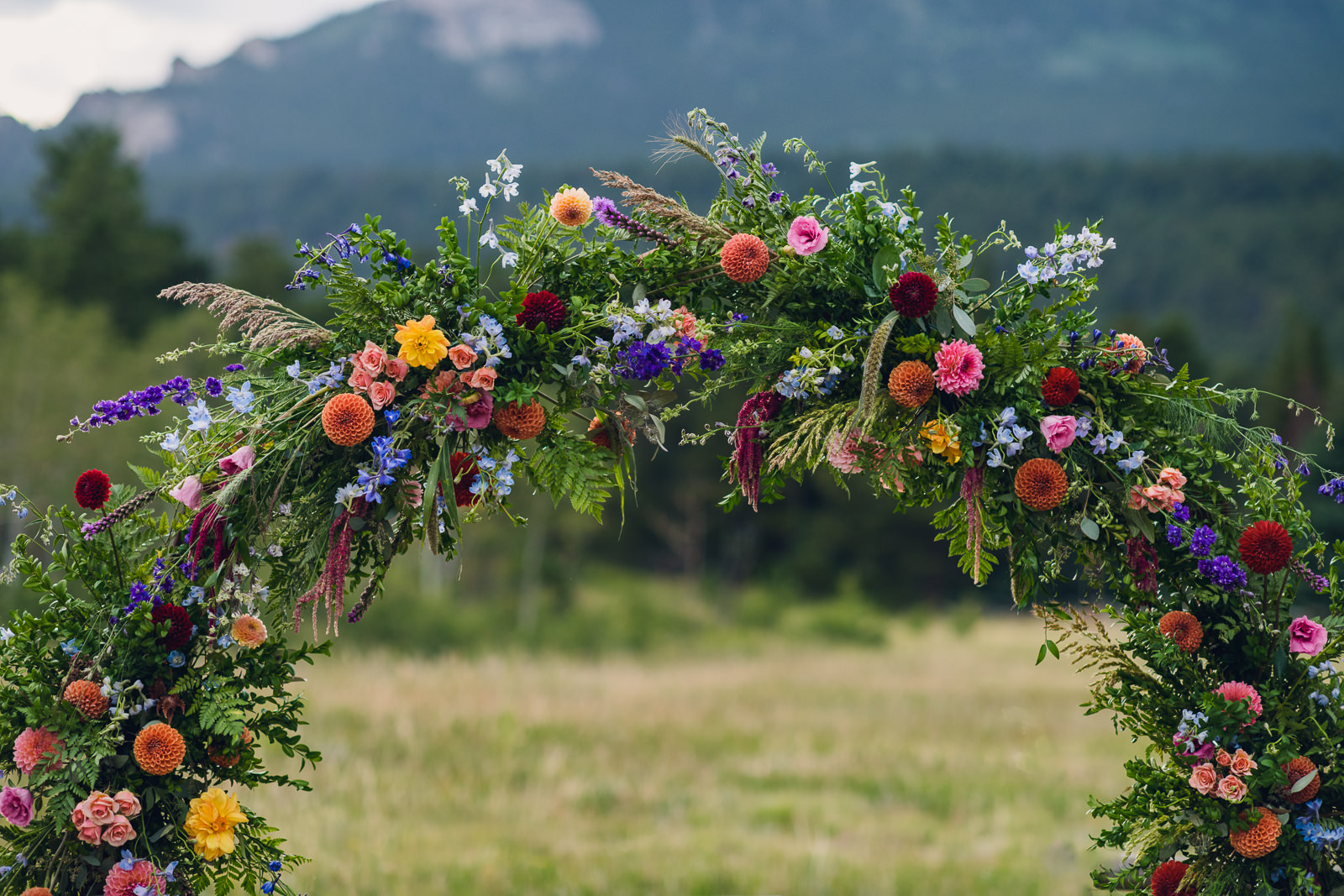 colorful floral circle arch for luxury wedding ceremony in the mountains
