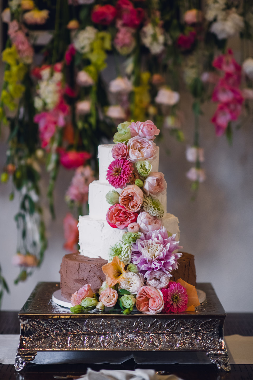 ellens-citrus-wedding-web-98 wedding cake with cascading flowers in front of a matching floral backdrop