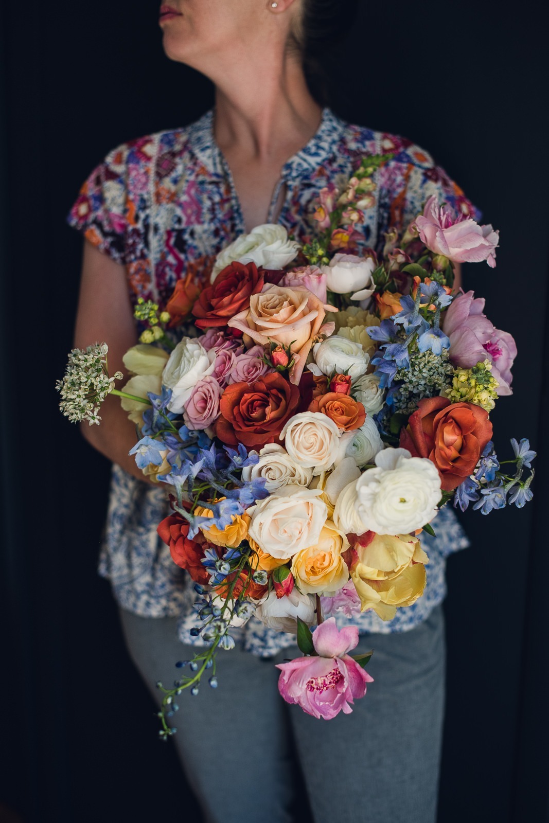 wild-blossoms-heather-taylor-wild-basin-lodge-wedding-web-15 copy woman holding a bridal bouquet of refined colorful citrus wedding flowers