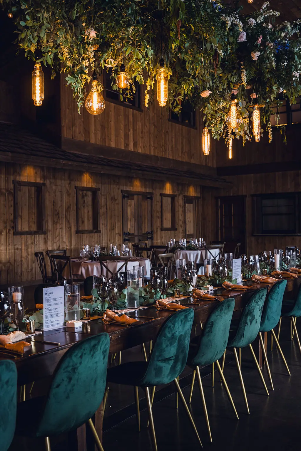 wild-blossoms-sami-pate-spruce-mountain-wedding-web-108 hanging floral installation with lighting over Wedding reception table with emerald chairs at spruce mountain colorado
