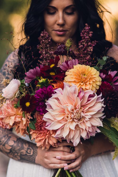 woman holding her lush dahlia bouquet during autumn equinox retreat in colorado