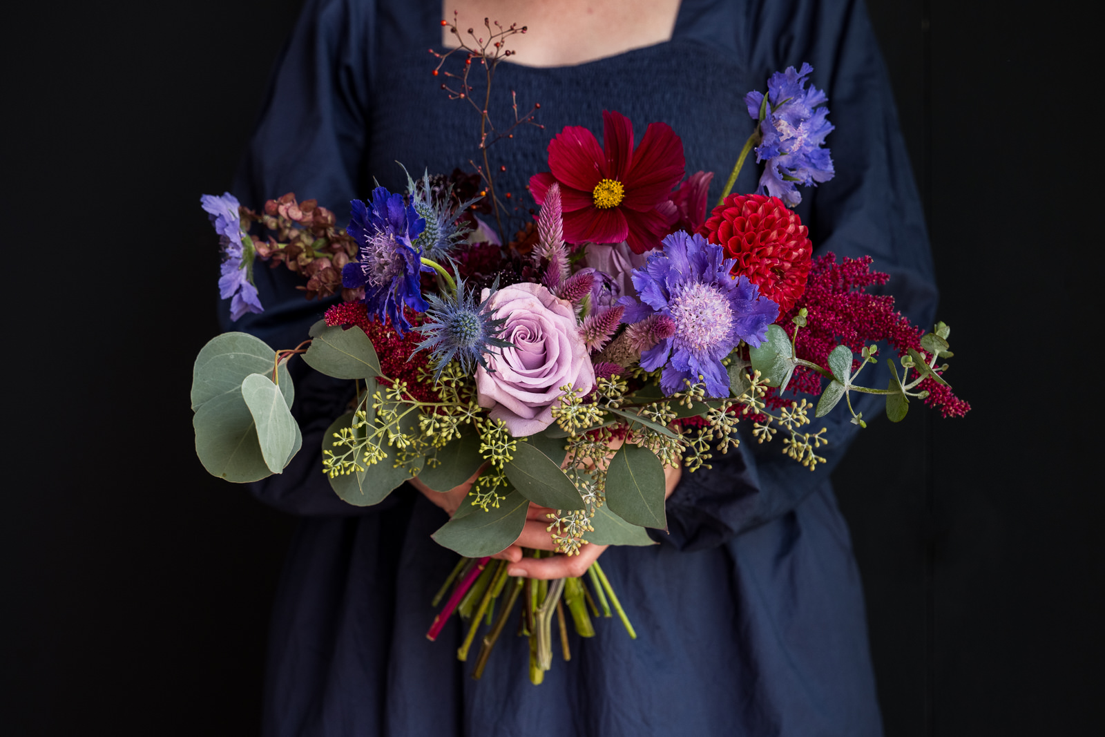 woman holding jewel tone bridesmaid bouquet for estes park colorado wedding